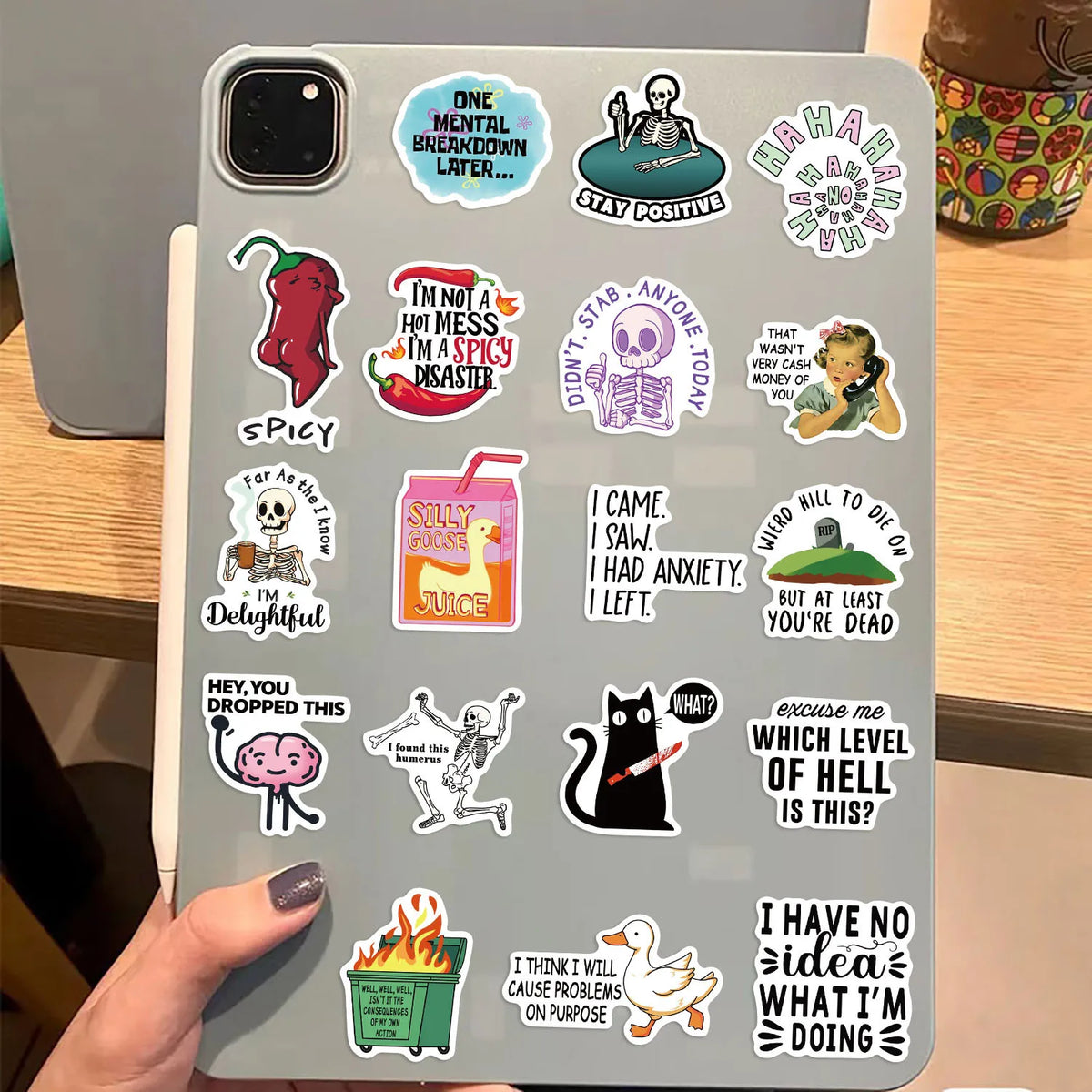 A close-up of a phone case decorated with various funny and snarky meme stickers.