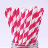 A bundle of pink and white striped paper drinking straws in a glass container.