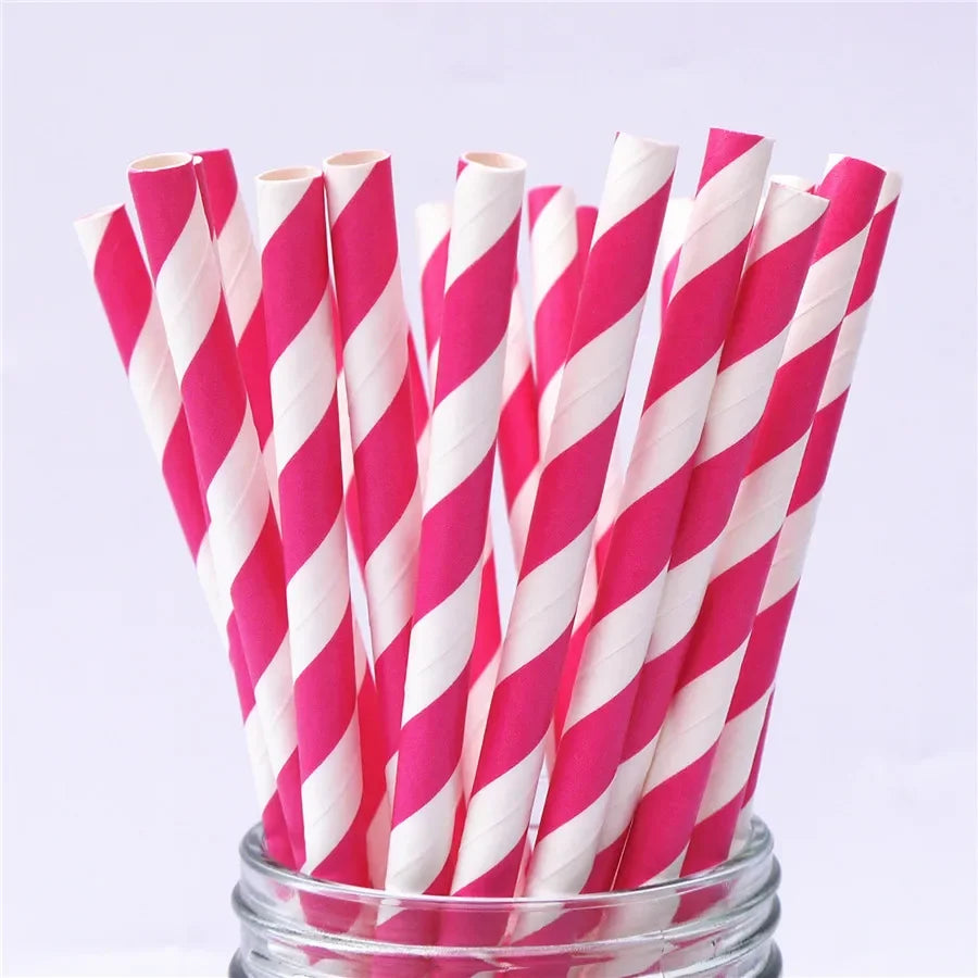 A bundle of pink and white striped paper drinking straws in a glass container.