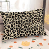 A decorative pillow cover featuring a black and tan leopard print on a white background.