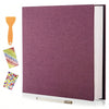 A purple linen scrapbook photo album with a spine visible and an orange glue stick next to it.