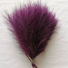 A vibrant purple artificial pampas grass bouquet used as boho home decor.