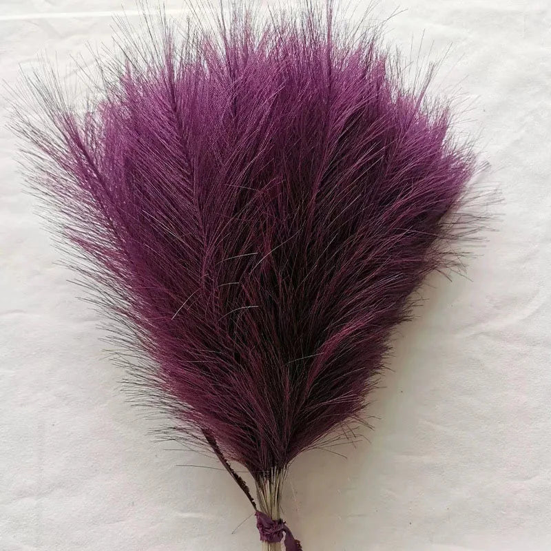 A vibrant purple artificial pampas grass plume used for boho wedding and home decor.
