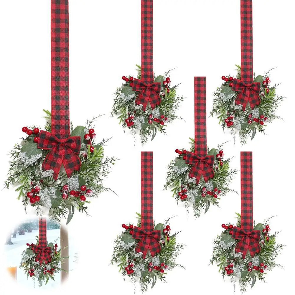 A vertical display of a 10-inch artificial Christmas wreath with red berries and a velvet bow on a plaid ribbon.