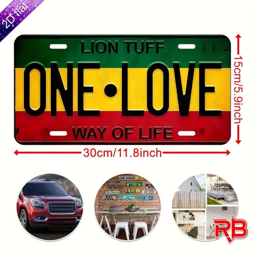 A rectangular metal wall sign featuring the text ONE LOVE in yellow on a black background with red and green stripes.