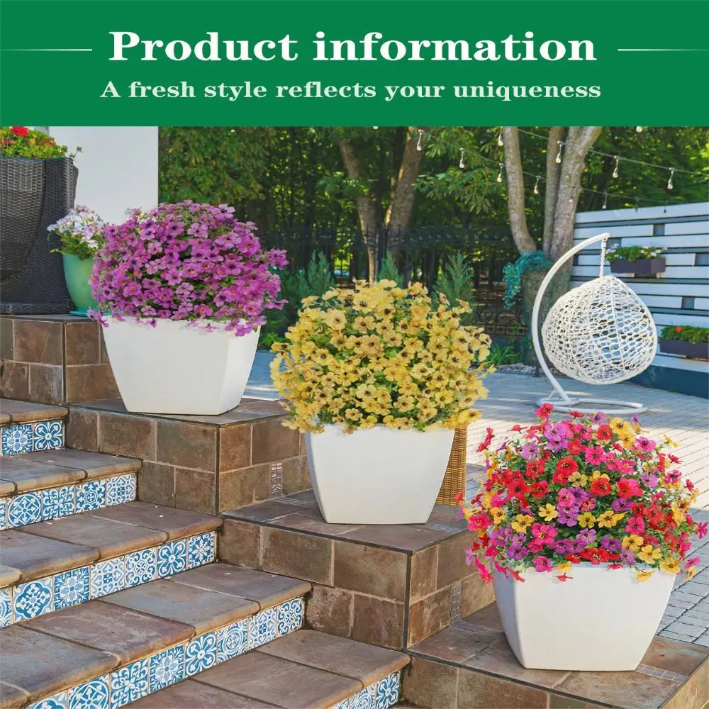 A display of colorful artificial flowers, including purple and yellow blooms, in white pots on stone steps.