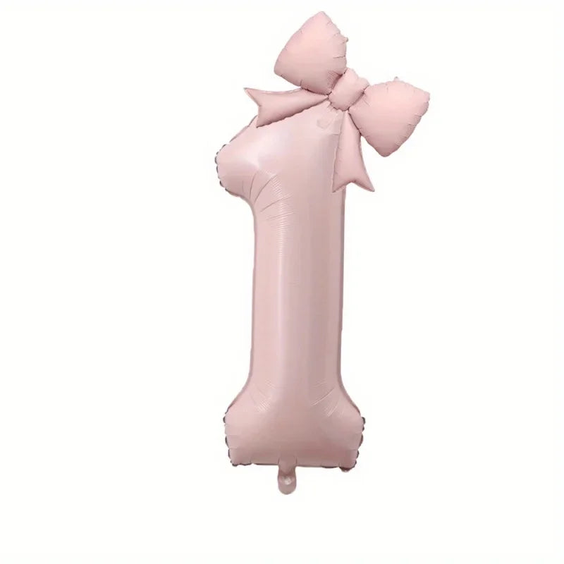 A large pink foil number balloon shaped like the number 1 with a bow.