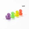 Eine Sammlung von fünf buntigen 3D-gedruckten Mini-Entenfiguren in lila, grün, gelb, orange und rosa.