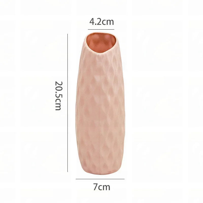 A tall, elongated, pink plastic vase with a textured surface.
