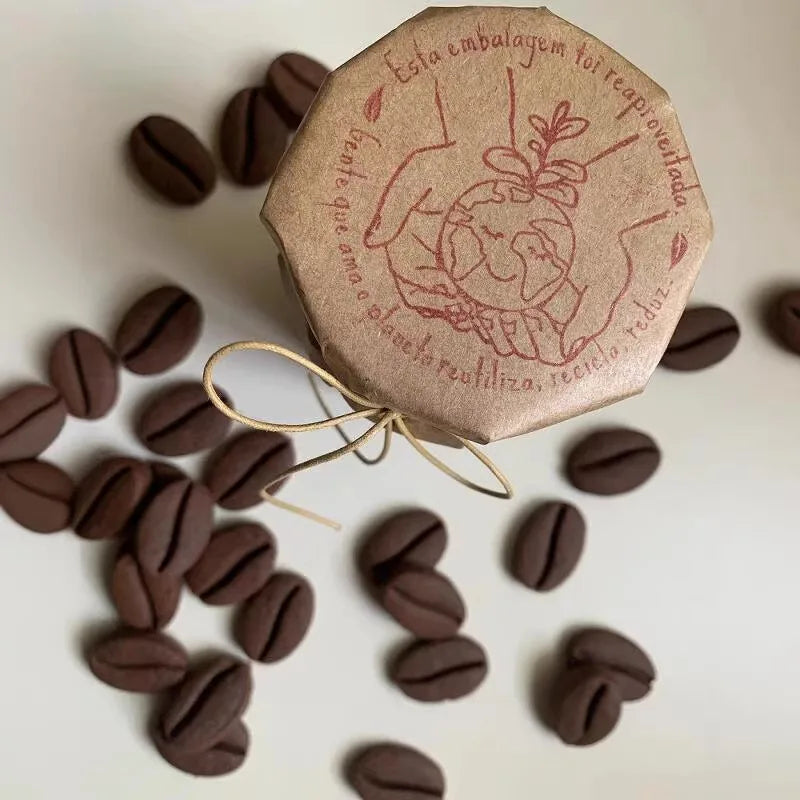 A brown coffee bean stamp mold is shown with loose coffee beans scattered around it.