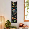 A dark tapestry featuring celestial elements like the sun, moon, and galaxy alongside various mushrooms and flowers.