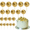 A set of twenty gold spherical cake toppers on sticks arranged in rows.