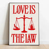 Rotes Zitatdruck auf weißer Leinwand mit den Worten 'Love is the law' ausgeglichen von einer Waage.