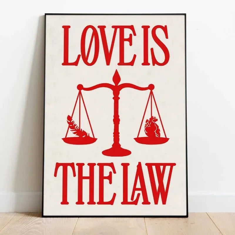 Rotes Zitatdruck auf weißer Leinwand mit den Worten 'Love is the law' ausgeglichen von einer Waage.