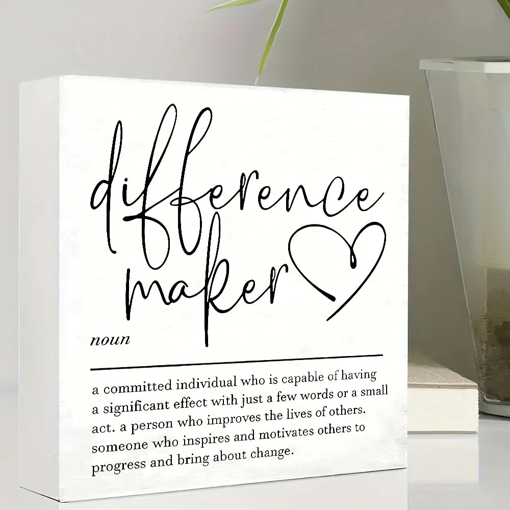 A white sign with black script that reads difference maker and a definition below it.