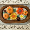 A silicone mold kit for making fall pumpkin scented candles featuring orange and yellow flower shapes.