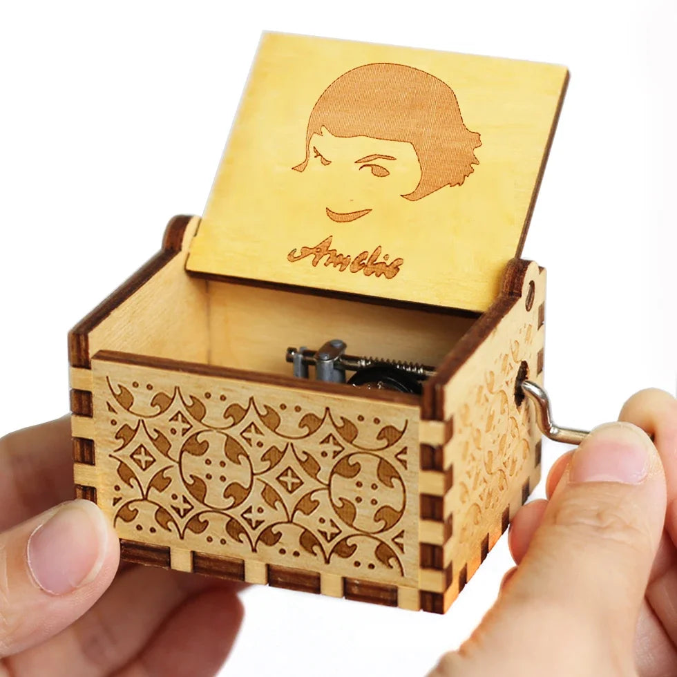 A hand holds an open carved wooden music box featuring a profile of a woman.