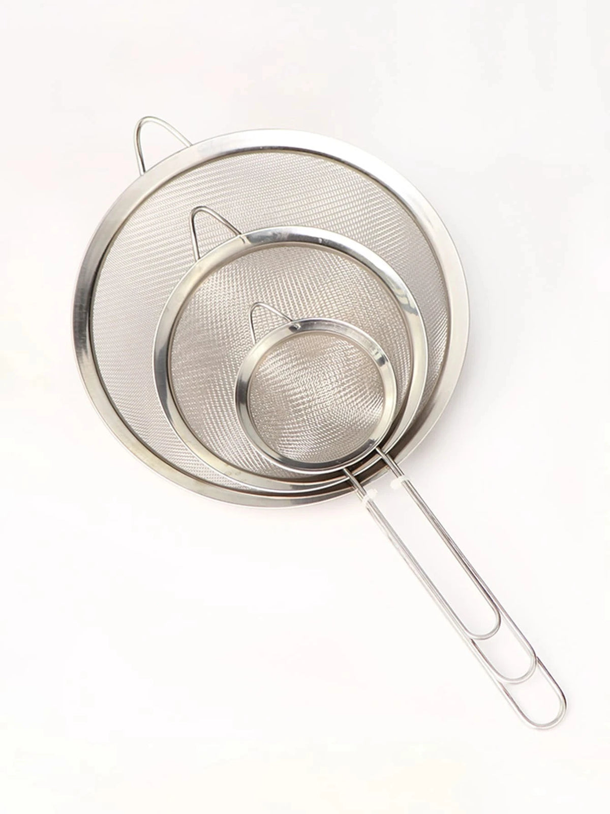 A set of three stainless steel colanders and strainers with wire handles.