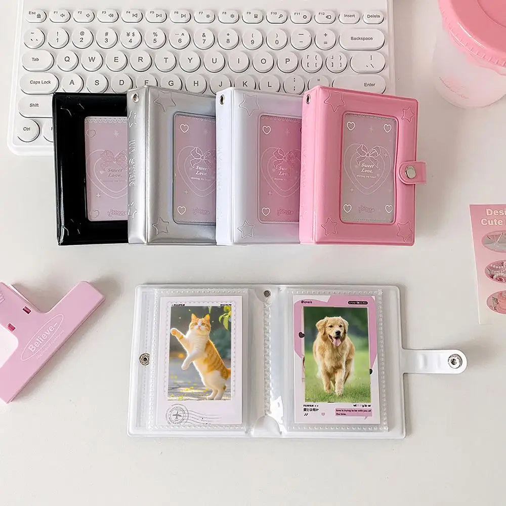 A collection of pink and silver compact photo card holders and a white album with dog photos.