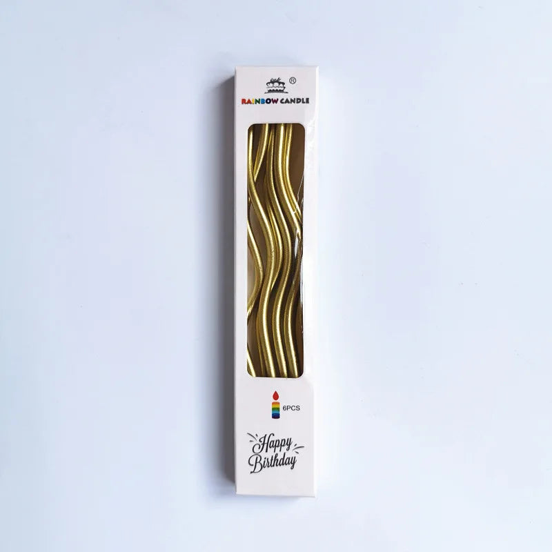 A vertical box of curved metallic birthday cake candles with a gold finish.