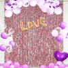 Festlicher Hintergrund mit rosa Tinselvorhängen und lila Ballons mit dem Wort LIEBE