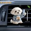 A white acrylic teddy bear puppy is shown holding a drink and a smartphone, placed inside a car vent.