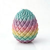 A 3D printed dragon egg stress relief toy with a colorful, iridescent gradient of pink, purple, and yellow.