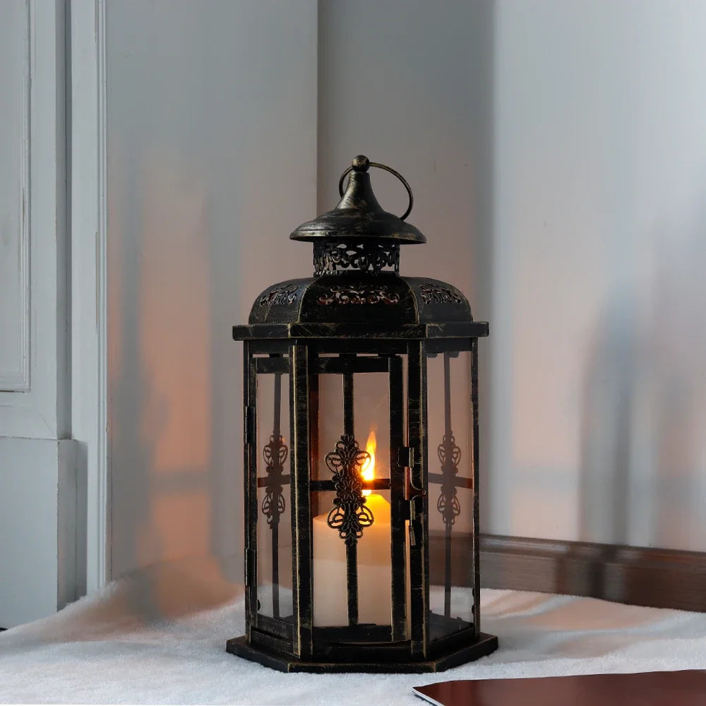 A vintage Nordic iron candle lantern with glass panes sitting on a white surface.