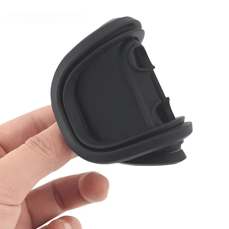 A hand holds a black silicone car door lock protector with rubber bumper pads.