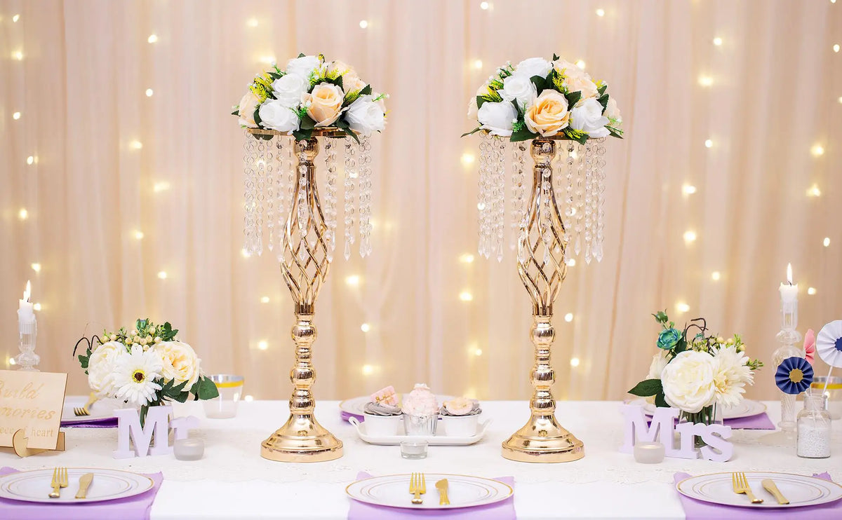 A gold-toned rose ball centerpiece with silk artificial flowers displayed on a white table.