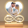 A glowing acrylic photo frame featuring a heart shape with names Rachel and Steven and a date 12.25.2024
