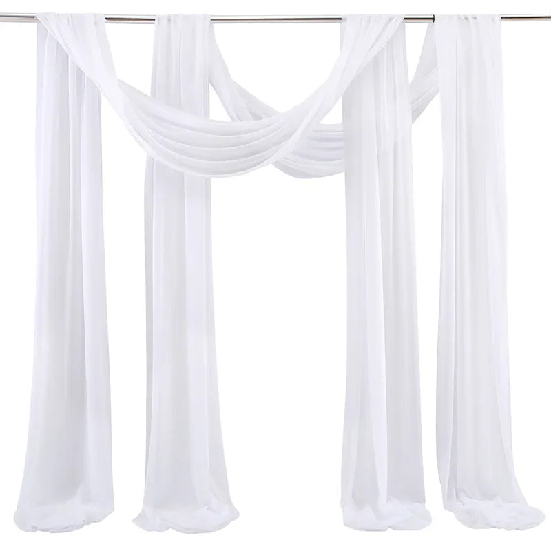 A set of two white chiffon wedding arch draping fabric panels hanging on a clothesline.