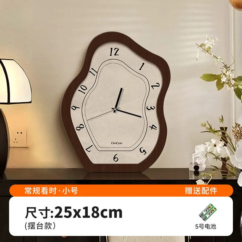 A wooden wall clock with a light gray face and black hands is displayed on a dark surface.
