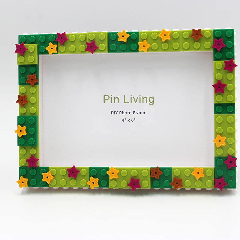A DIY photo frame made of green and yellow blocks with pink and orange star decorations.