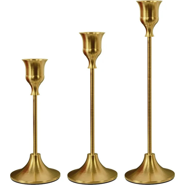 A set of three brass vintage metal candle holders with tapered tops and wide bases.