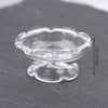 Clear glass miniature dollhouse vase and wine bottle set resting on a dark surface.