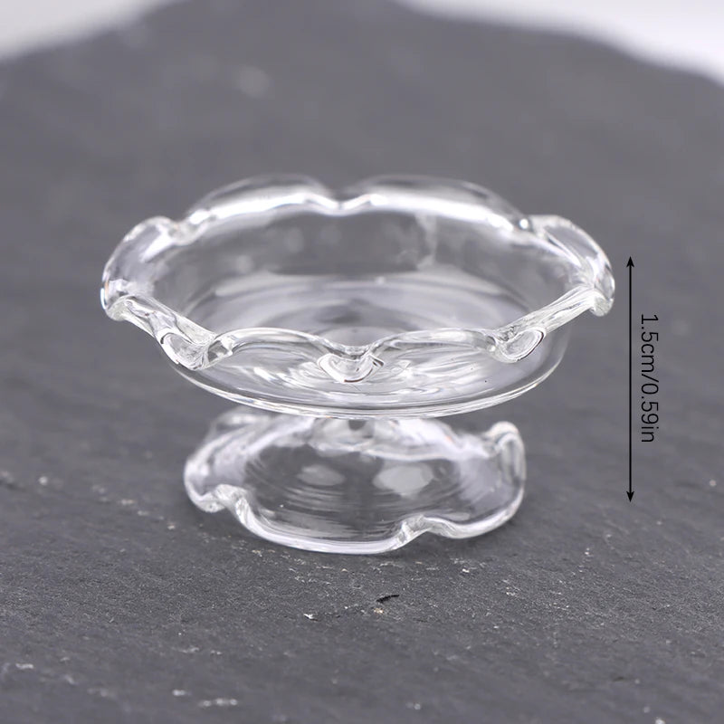 Clear glass miniature dollhouse vase and wine bottle set resting on a dark surface.