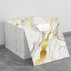 A stack of self-adhesive marble tile stickers featuring white and gold veining on a gray background.