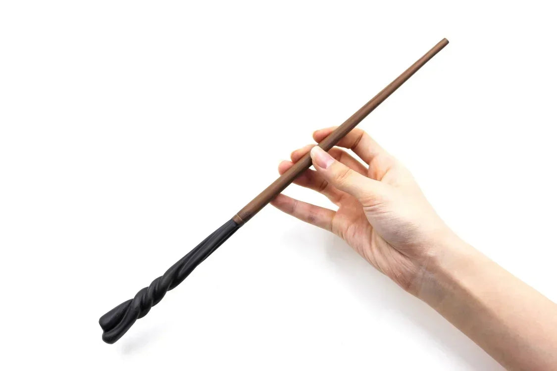 A hand holds a dark brown, twisted metal magic wand against a white background.