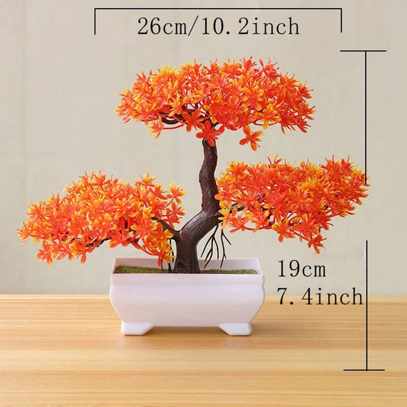 An artificial tree bonsai decoration with bright orange foliage planted in a white rectangular pot.