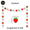 A garland of strawberry-shaped decorations for a birthday party, including individual strawberries and a central fruit.