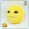 A yellow, round plush doll resembling a distressed face is shown next to a hand for scale.