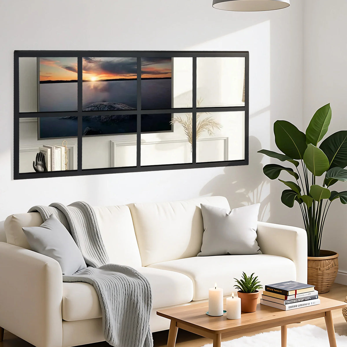 A modern black framed window mirror reflecting a sunset and interior decor in a living room setting.
