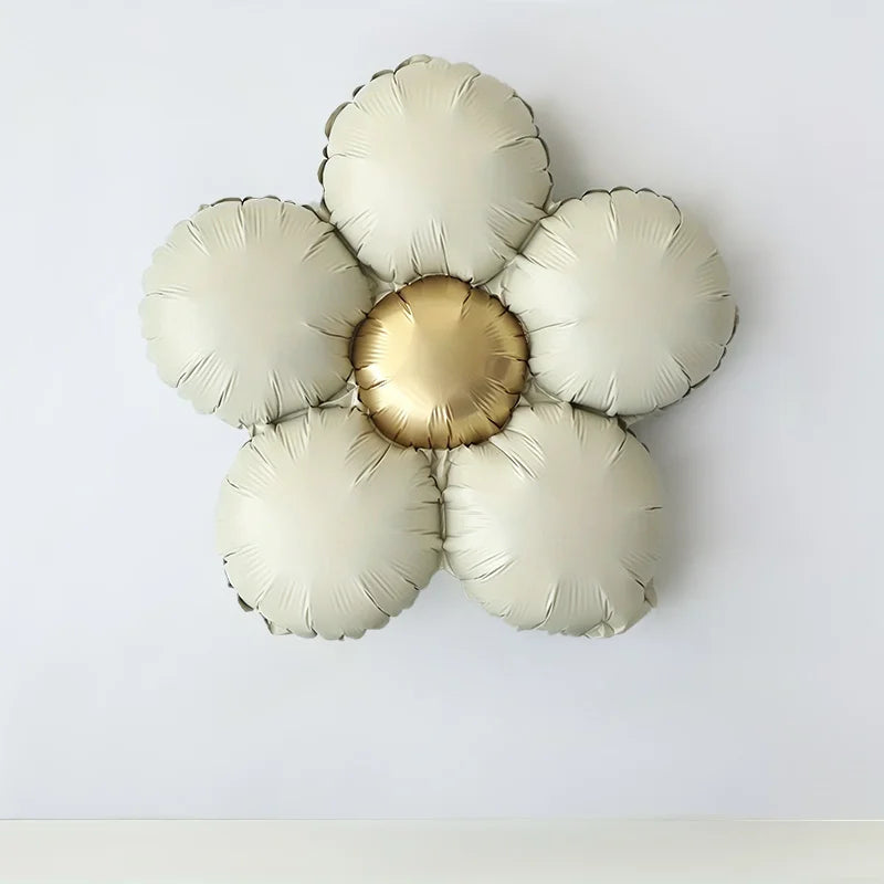 A set of five matte gold foil balloons shaped like flowers, including one central balloon with a gold finish.