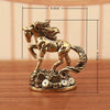 A solid copper figurine of a rearing horse with a flowing mane, displayed on a wooden surface.