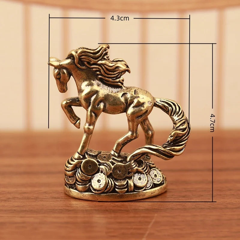 A solid copper figurine of a rearing horse with a flowing mane, displayed on a wooden surface.