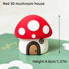 A red 3D mushroom house cake topper with white polka dots and a small wooden door.