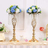 A set of gold crystal vases with floral arrangements used as wedding centerpieces.