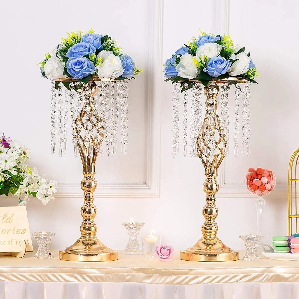 A set of gold crystal vases with floral arrangements used as wedding centerpieces.
