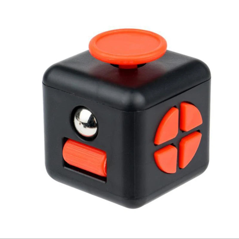 A black fidget cube with an orange top and four orange buttons.